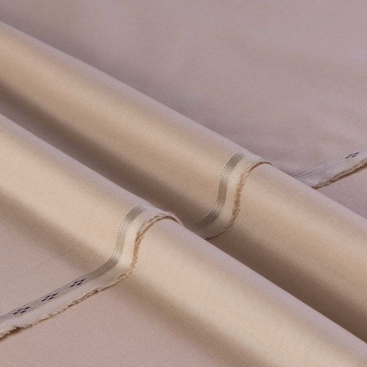 Close-up of beige fabric with a subtle pattern on a plain background