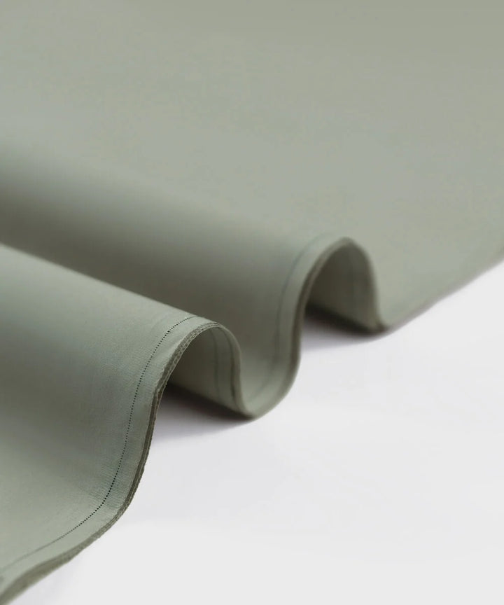 Folded light green fabric on a white background