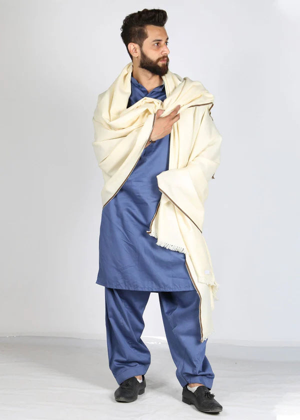 Man wearing a blue traditional outfit with a beige shawl on a white background